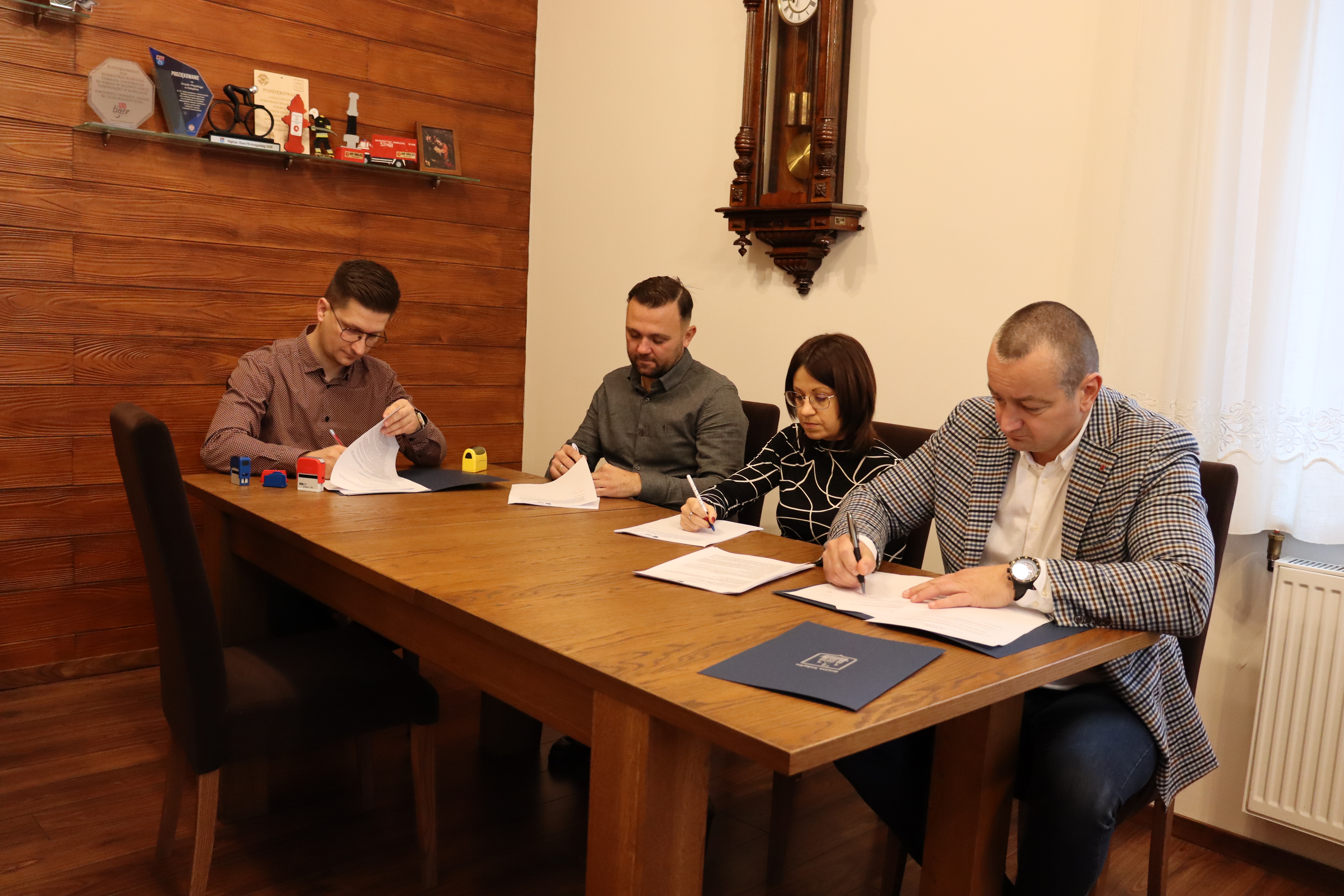Cztery osoby podpisują umowę w gabinecie burmistrza Kobylina 